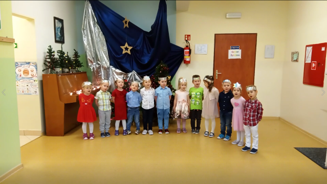 dzieci stoją przed świąteczną dekoracją i mówią wiersz