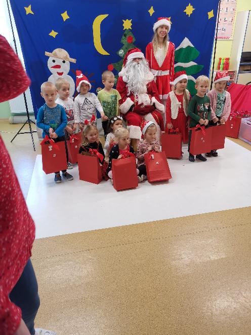 grupa z Mikołajem dzieci trzyma prezenty