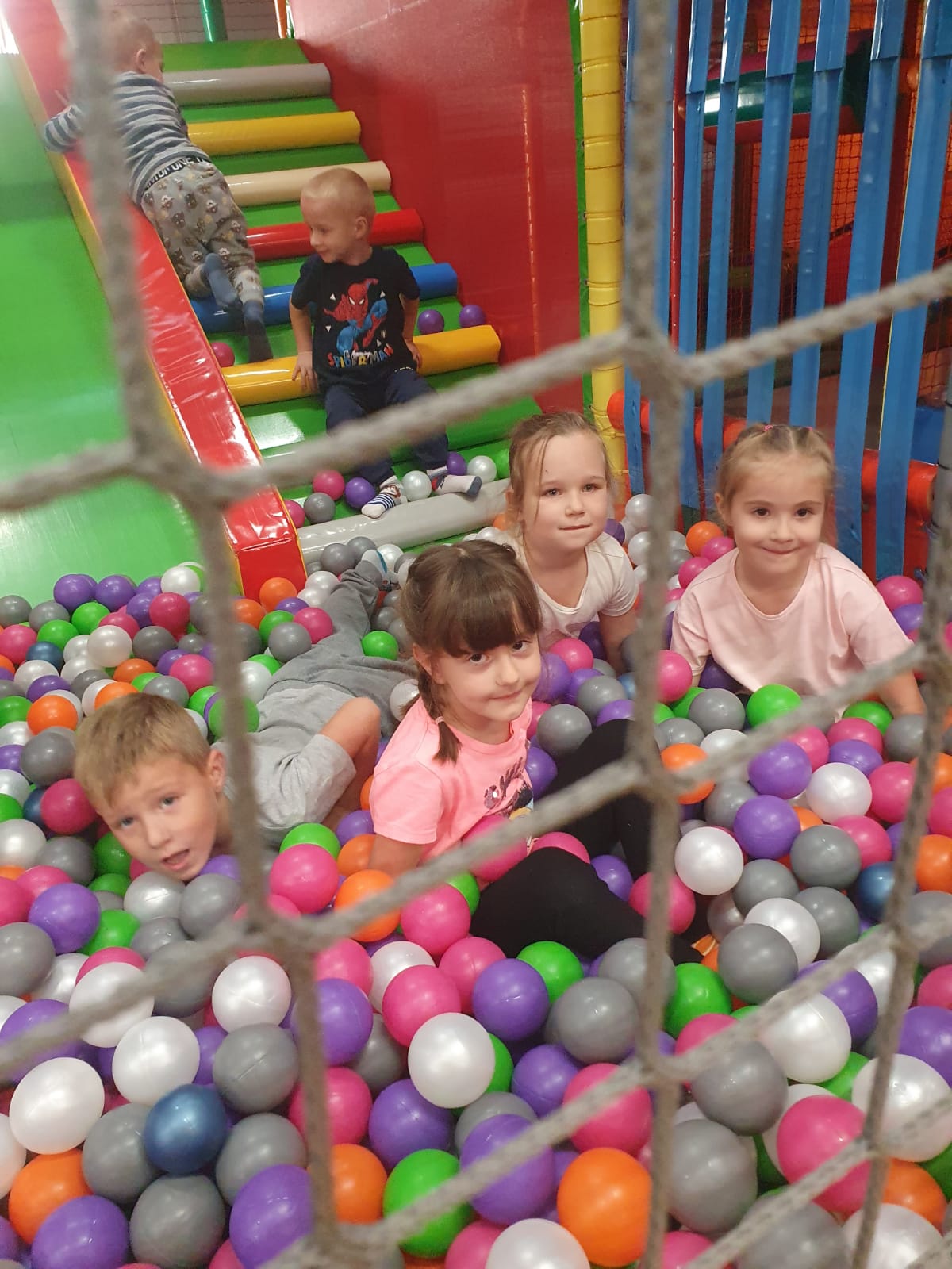dzieci w kolorowych piłkach w sali zabaw
